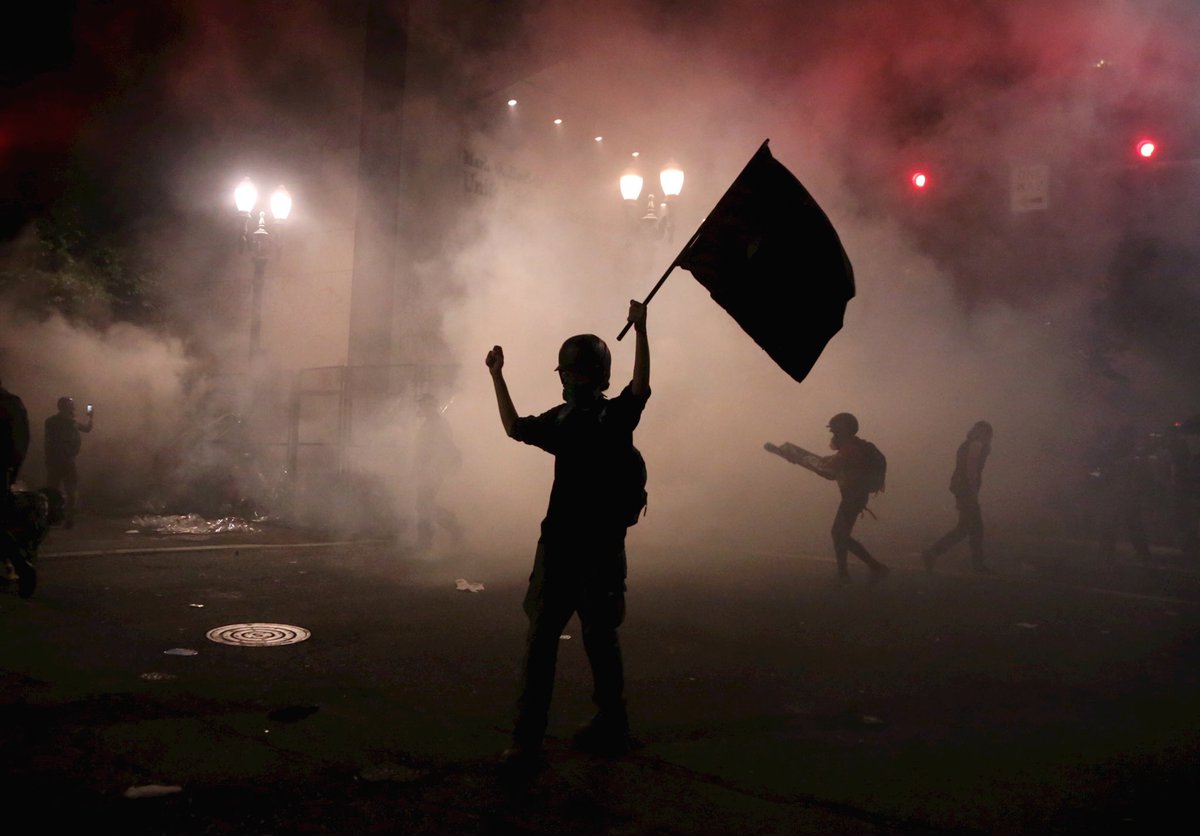 Police are throwing some sort of gas canisters, also flash bangs, the still decent sized crowd is energized, throwing firecrackers right back at LE still behind the courthouse fence. I can hear This is America playing and that's about right