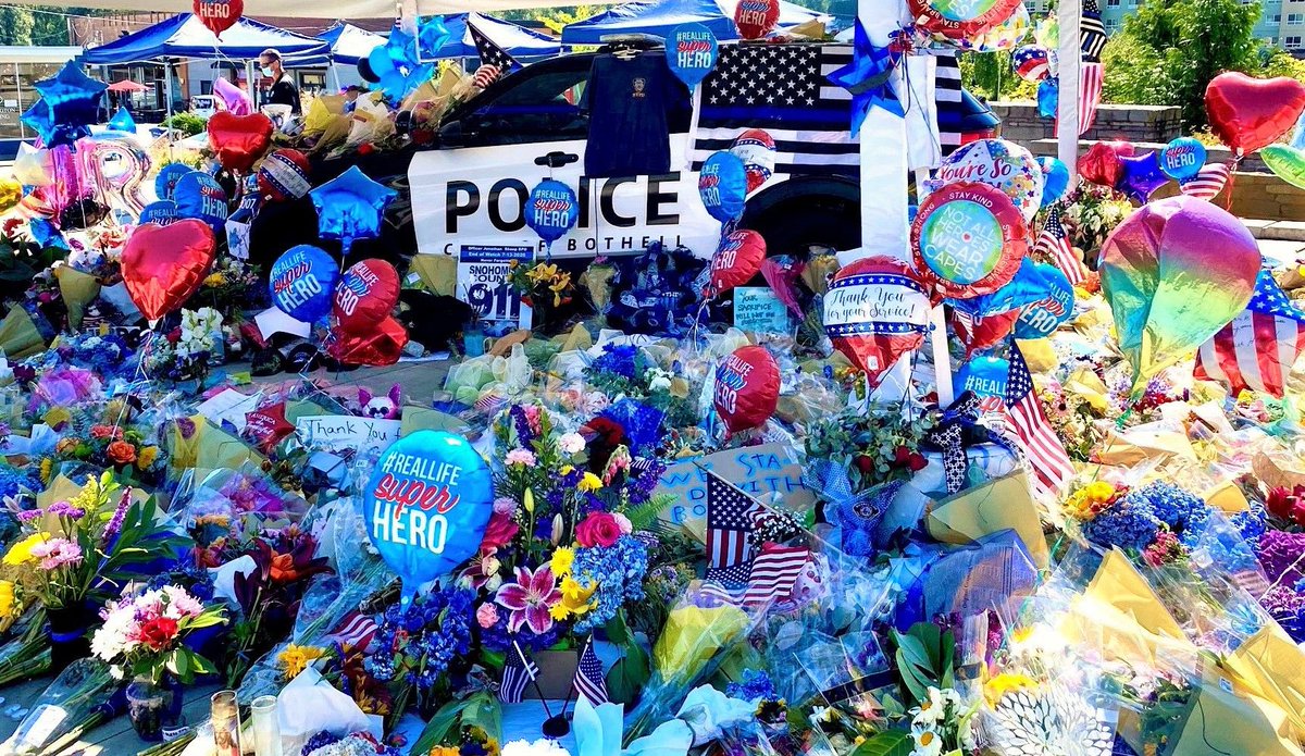 BothellPolice's tweet photo. We are truly humbled by the outpouring of support for Officer Shoop at the City Hall Plaza. Please take time this weekend to visit and reflect before the memorial is moved to the front of the department, early next week. https://t.co/QNI7NDvcS1