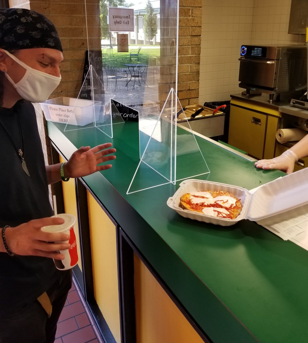 COWDining's tweet photo. College of Wooster Senior Joe Naser is the first Mom's Cafe customer to try a Naan Bread pizza, cooked lightening fast in our new oven.  Staff has been training and perfecting recipes for two weeks.  Mom's officially reopens Tuesday August 11 with a brand new, plant-forward menu. https://t.co/kN4bus4V6X