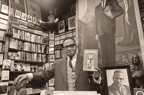 Behind Malcolm is the National Memorial African Bookstore, run by Lewis Michaux, and also known as the "House of Common Sense and Home of Proper Propaganda." With 100k books, it was a bookstore but also a library for African American intellectuals seeking radical ideas. 3/