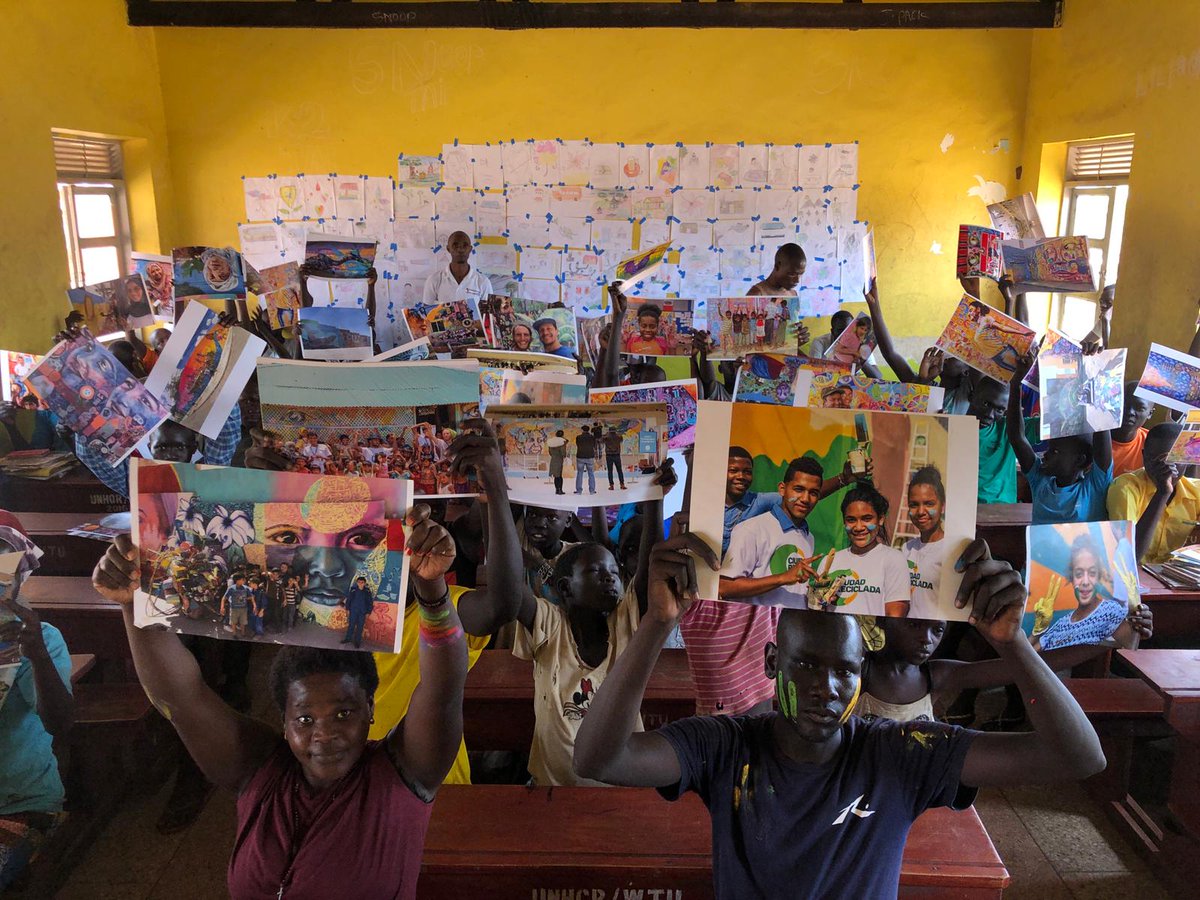 ArtolutionOrg's tweet photo. A look back at students and educators from the Bidi Bidi refugee settlement in Uganda holding up the images of previous Artolution projects.
At the start of all workshops, we share these photos to connect our participants to one global #Artolution community. #jointheartolution https://t.co/gYQF6coHRd