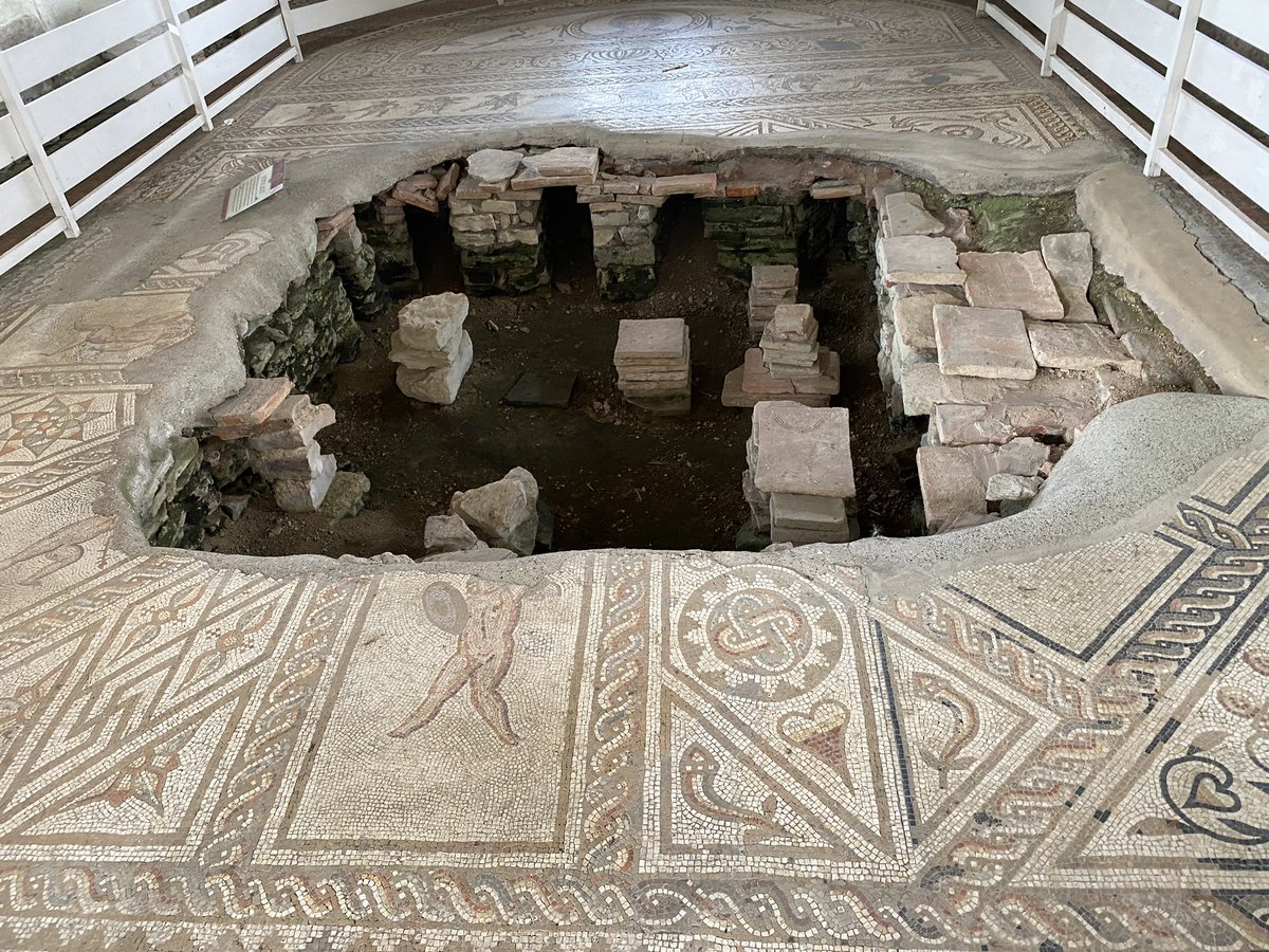 Next is the Venus and Gladiator mosaic. This room was probably used as a winter dining room as it has under floor heating. At the top is Venus flanked by two birds and fern with inlaid glass. Some of the mosaic has been destroyed when the hypocaust collapsed beneath it.