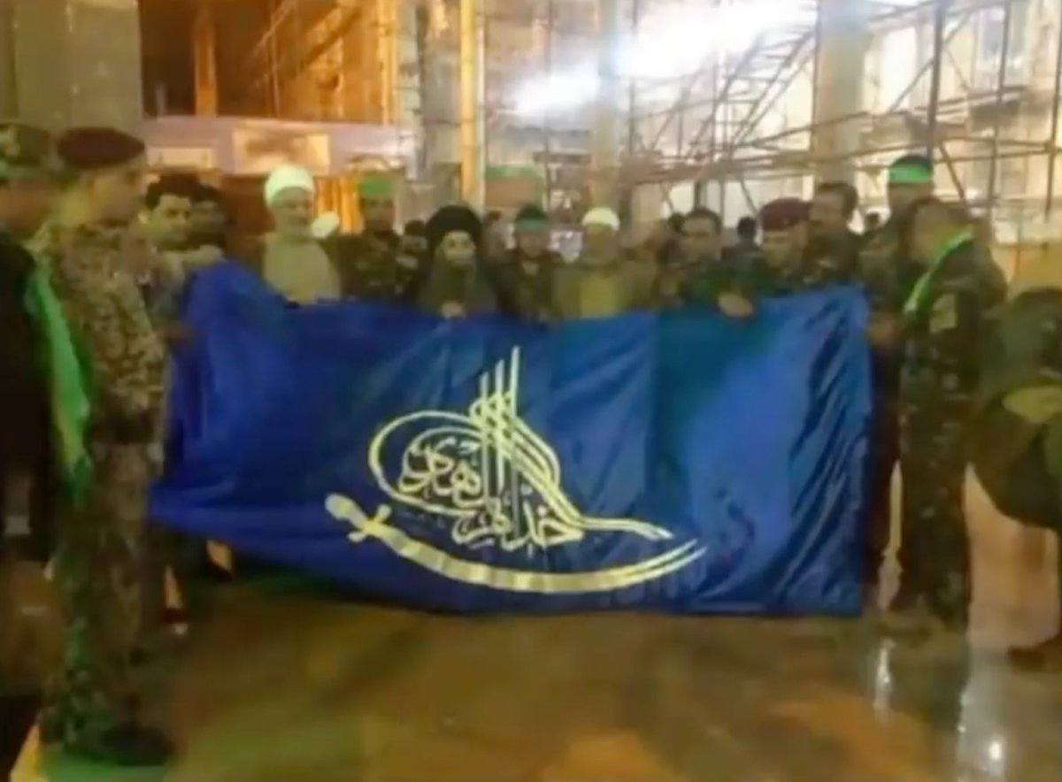 Soldiers of the Iraqi army waving the flag of Yasser al Habib's militia, Khoddam al Mahdi.