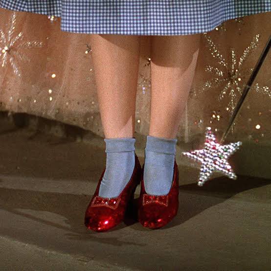 Dorothy Gale from The Wizard of Oz. Originally silver, the color of the shoes was changed to red shoes or ruby slippers to take advantage of the new Technicolor film process.