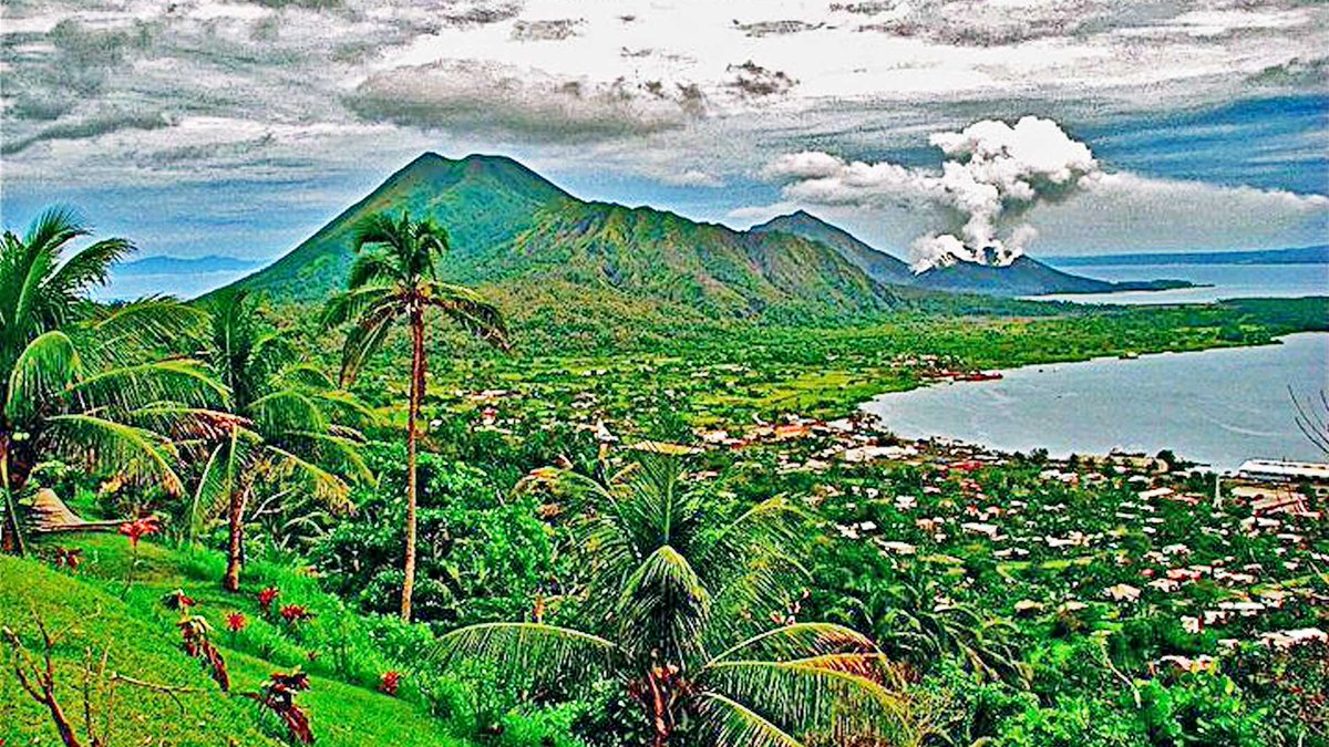 2/6: Rabaul as it was: 100,000 Japanese troops were based here in WW2. The main Indian POW camps were on the distant shore at top right of picture. Rabaul is surrounded by extinct, dormant & active volcanoes. The smoking volcano is Tavurvur: it virtually destroyed the town- 1994.