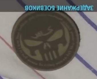 These are patches the arrested Russians allegedly had on them. The one on the left says something like “we’re all gonna die anyway” in Russian. The one on the right says “Infidel” (on the forehead of the Punisher skull) in Arabic.