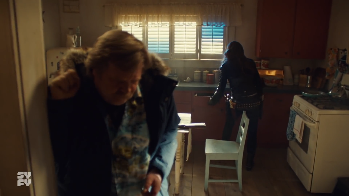 Now the table is hidden behind Nedley & Wynonna, but at this point, nothing is happening behind them yet. Wynonna ends up going back into the kitchen to find that First Aid kit that they have... not. The shotgun is still there.