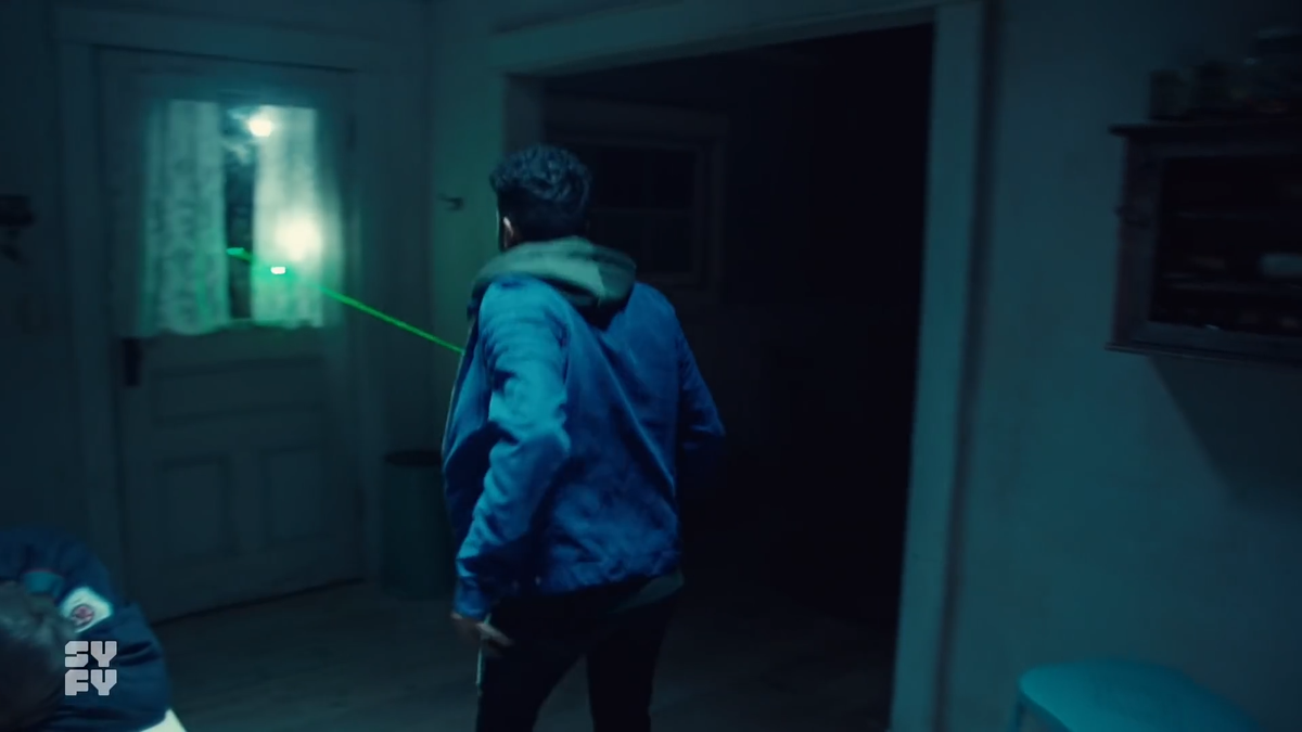 Now we see a laser sight on Jeremy which is being pointed through the kitchen door window. It's not being done by the BBD Agent (yes the credits call him BBD Agent).