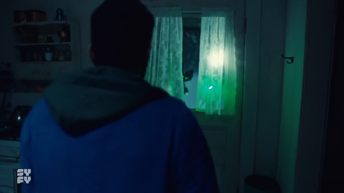 The commands to come out with your hands up is probably ADR, but I would assume someone on set said them to help guide the scene.As Jeremy walks to the door, a figure appears in the doorway behind who/whatever is pointing the laser.