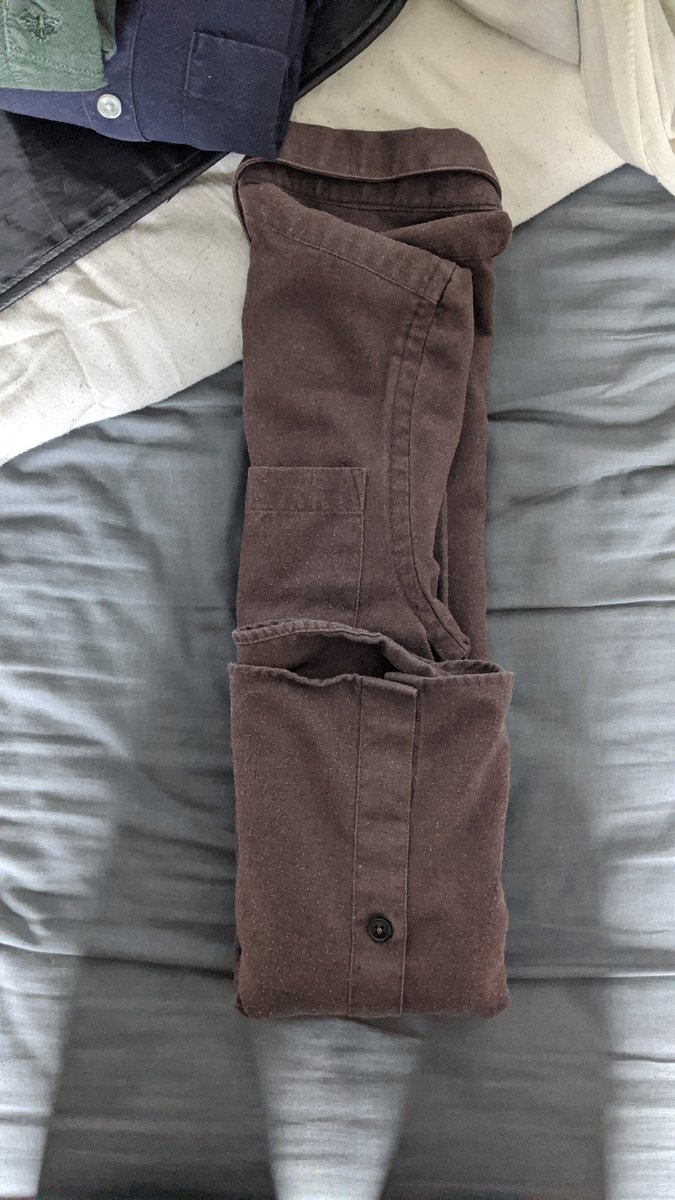 Step six: folding up from the bottom, fold the shirt into thirds again