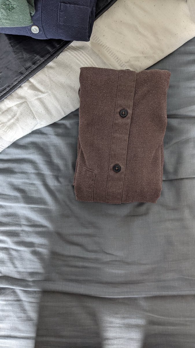 Step six: folding up from the bottom, fold the shirt into thirds again