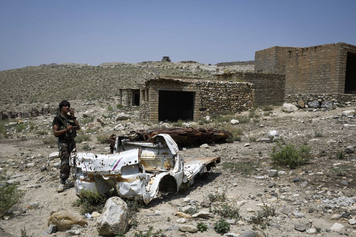 (5/9) An Afghan militia fighter stands next to two vehicles locals said were destroyed by U.S. airstrikes during the campaign against Islamic State. The cars are in a marketplace that is still abandoned after fierce bombardment.