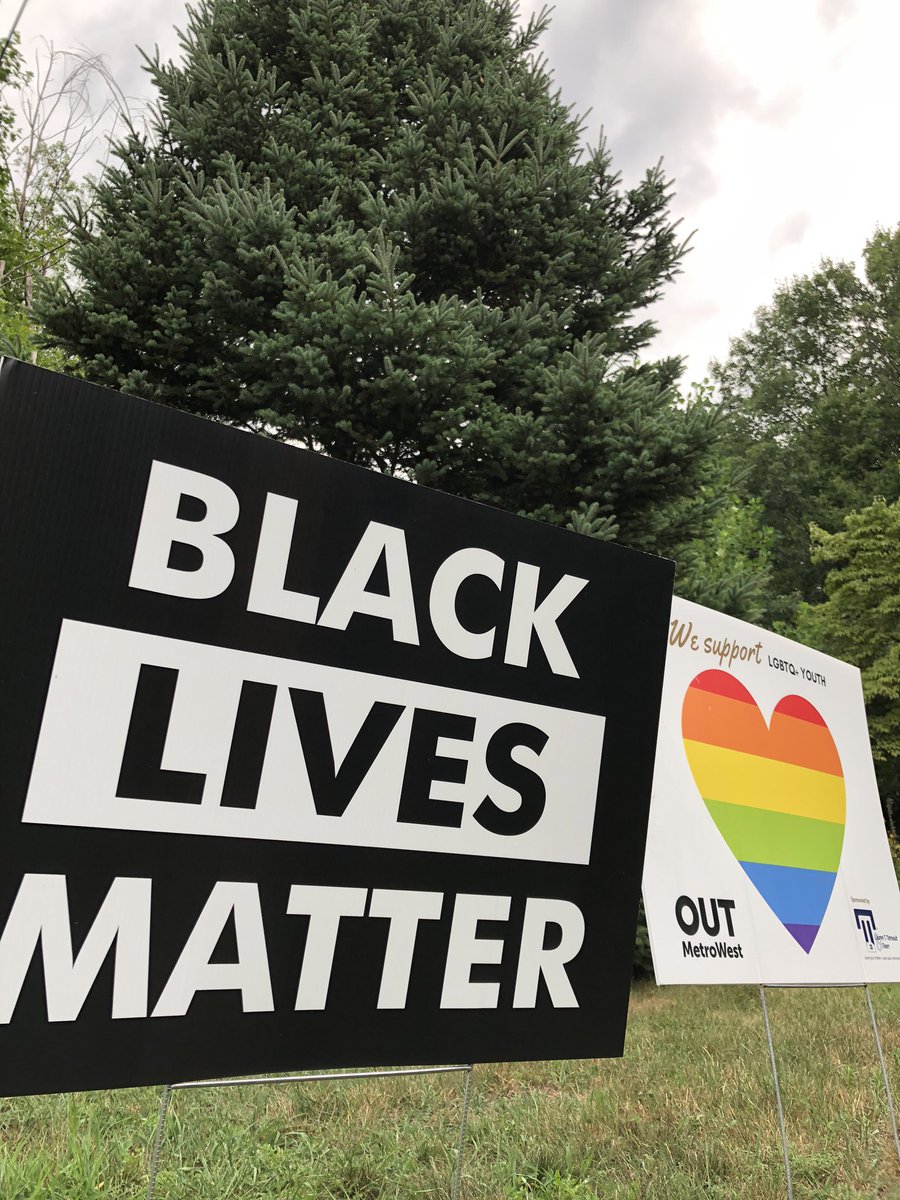 BLM lawn sign in foreground and OUT MetroWest rainbow heart lawn sign in background