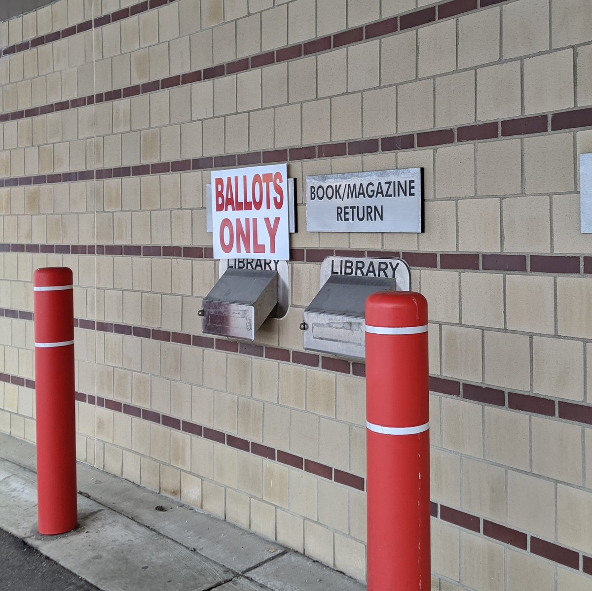 Ballots only depository in wall of building, next to a book/magazine return