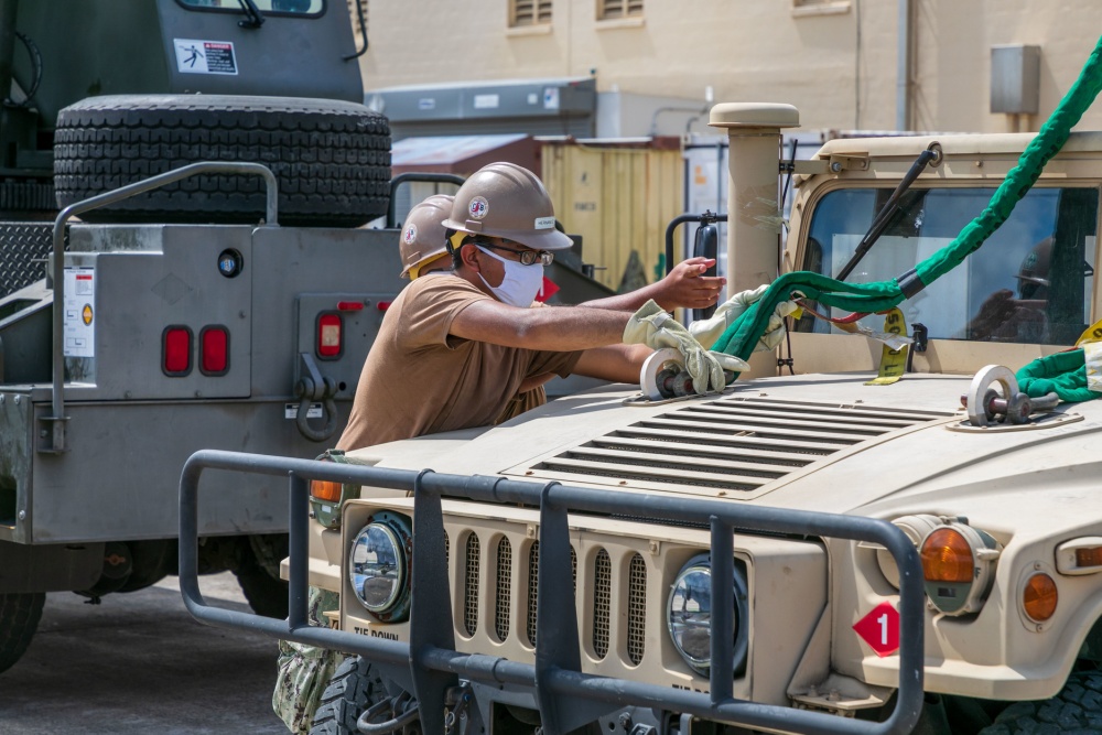 USPACOM's tweet photo. Seabees assigned to Naval Mobile Construction Battalion #NMCB1 in Guam perform turnover lifts with a Humvee as part of the battalion evaluation equipment program #BEEP demonstrating the crane is in proper working order. #ForgedByTheSeabees #FreeandOpenIndoPacific. https://t.co/O35ha0oisc