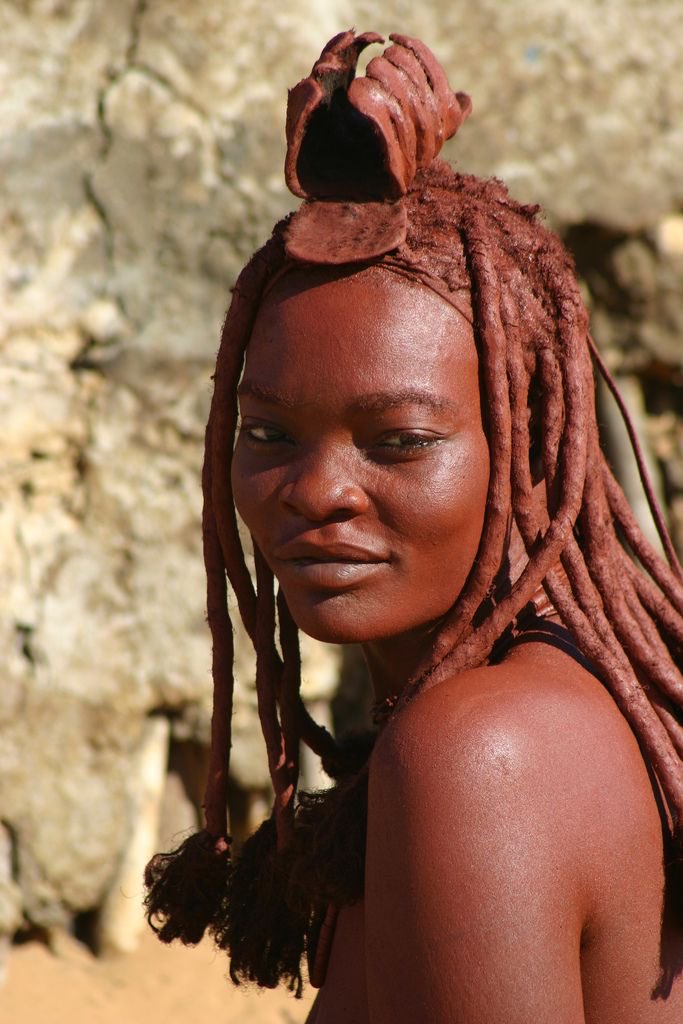 The Green Man reunites with the Red Woman, who is inspired by the Himba women of Namibia and Angola. Their reddish tone is made from otjize, a combination of butterfat and clay that cleanses and protects the skin during periods of water scarcity.
