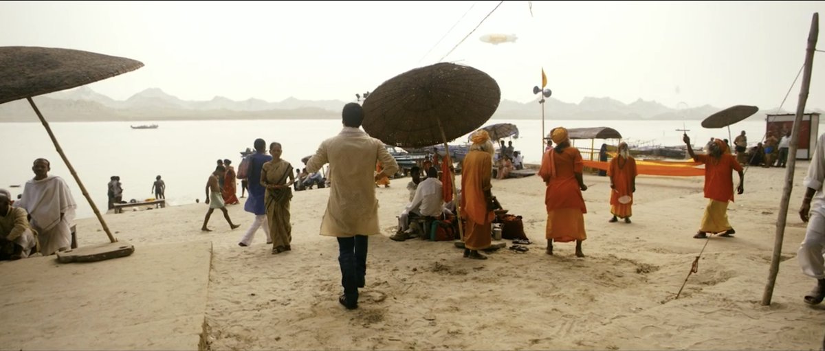 For eg background action. Inspired by Roy Anderson's films (writer  @SumitPurohit is a fan), there were all sorts of mini-stories going on. Here a bunch of sadhus are playing badminton by the ghats. There's also a blimp in the air.