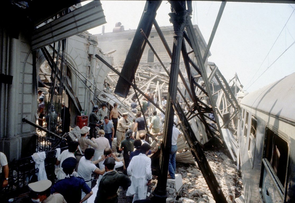 The blast is tremendous & the effects devastating. Part of the station building housing the waiting room & snack bar collapses. As well as in the building, the blast causes death, injuries & havoc on the train standing at Platform 1 & on the taxi rank in front of the station >> 4