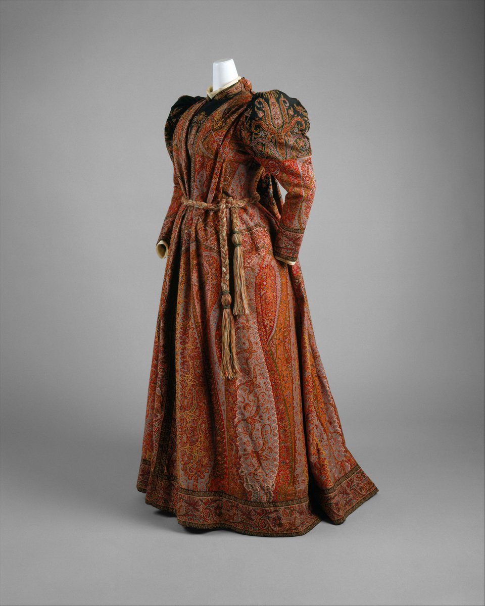 More elaborate than a wrapper, an at-home dress is worn to receive guests in the late morning or early afternoon. Later on, the tea gown served a similar purpose.