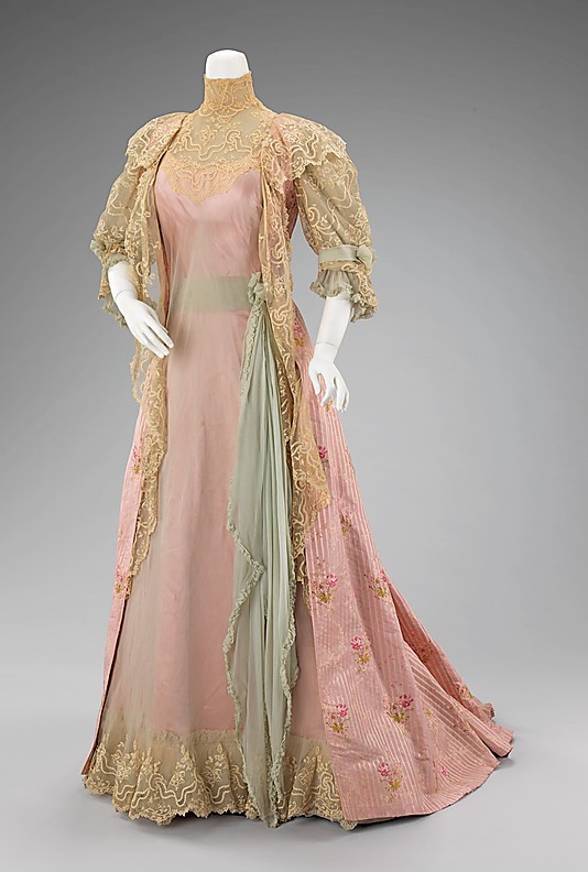 More elaborate than a wrapper, an at-home dress is worn to receive guests in the late morning or early afternoon. Later on, the tea gown served a similar purpose.