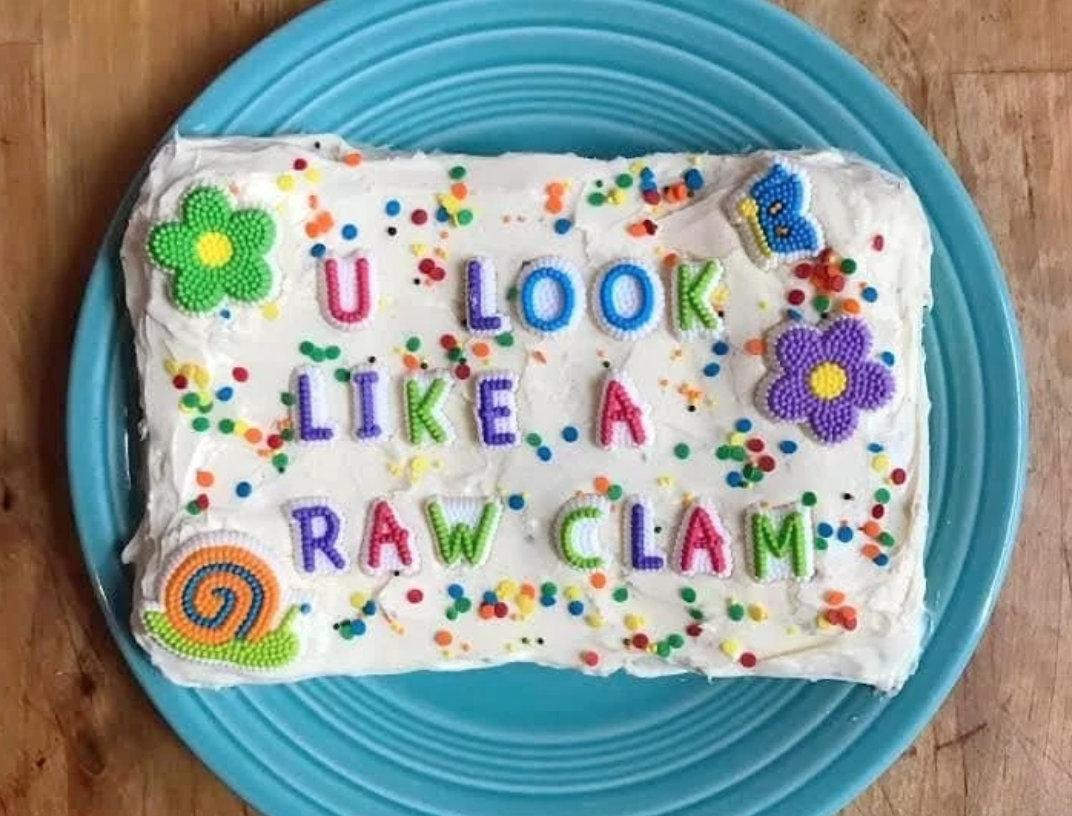 cake with "u look like a raw clam" written in sugar letters across it