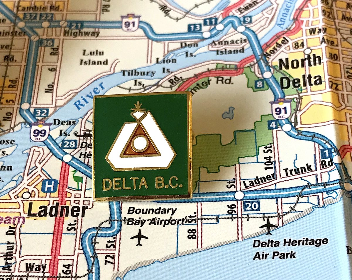 103. DELTA- Delta's flag is the 5th best in the province, but they ported that over to the pin, and doesn't work quite as well- Too square, too much green space, words take up too much space- Overall theme (triangle of communities, farming in the middle) still solid though