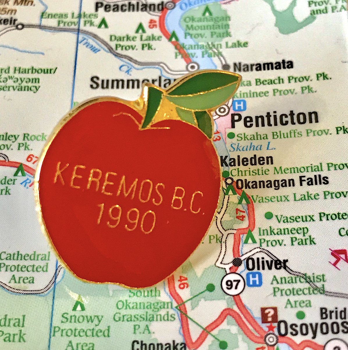 68. KEREMEOS- The spelling mistake on the apple is hilarious- Also Keremeos incorporated in 1956, what happened in 1990- Cute and on brand though- Modern corporate pin is not bad, "Kindness and Friendship" makes me smile