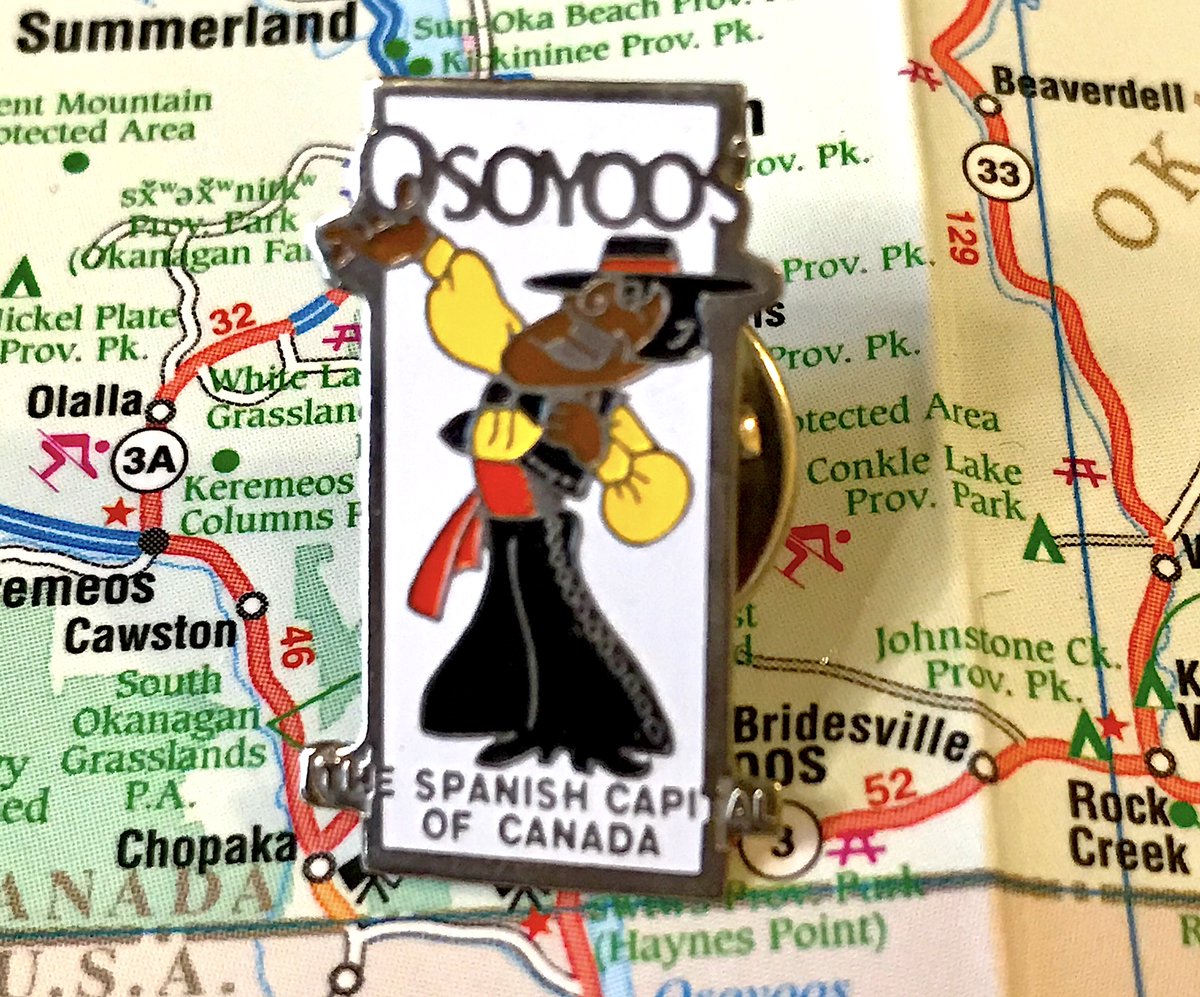 38. OSOYOOS- In the middle of the 20th century people in B.C. were VERY excited when a lot of their immigrants came from a specific european country- the man is so excited (to sing?) his hand is BREAKING OUT of the pin!- boring crest pin is boring and a crest