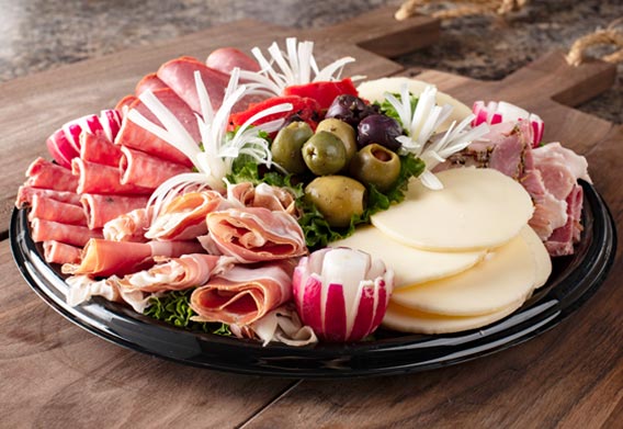 American delis sell cold cuts by weight and prepare party trays. Like Charcuterie boards! It's like they're cousins..
