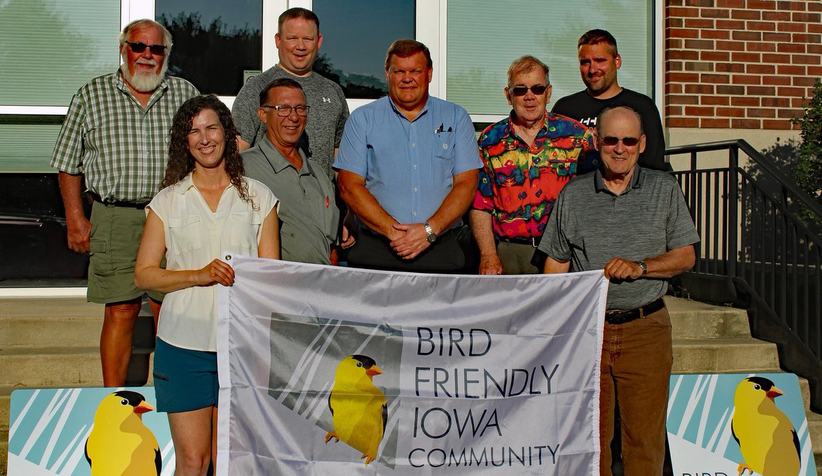 Denver city leaders show off their signs and flag designating them as an Iowa Bird Friendly Community.