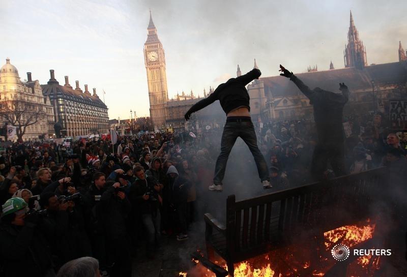 Some the great Reuters photographs done over the years by Andrew Winning. Demonstrators jump off burning park benches during a protest outside the Houses of Parliament in Westminster, central London December 9, 2010. REUTERS/Andrew Winning