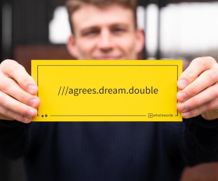 Person holdign what3words address sign