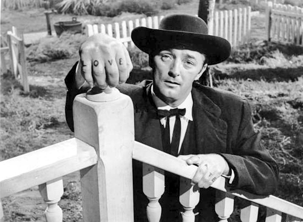 detrás de la cámara. Una obra maestra.Robert Mitchum es ese predicador que cita la Biblia y juega con los términos morales y espirituales.Un depredador nocturno cuyos nudillos portan las letras "amor" y "odio". La encarnación pura de las fuerzas del mal. Su creación sublime.