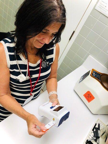 RobinCaudell's tweet photo. #SUNY Plattsburgh Student Health &amp; Counseling Center Director Dr. Kathleen Camelo holds a new COVID-19 test analyzer. The center has 1,000 test kits for this machine that returns results in 15 minutes. Read front-page story in Thursday's edition of the Press-Republican. https://t.co/GvCkXBVh8m
