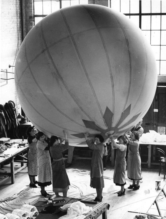 1938 A group of women workers hold aloft a large balloon during construction at the Abney Mews Stoke Newington balloon factory run by Ena Spencer, great grand-daughter of British pioneer balloonist Edward Spencer. (Photo by Fox Photos/Getty Images)