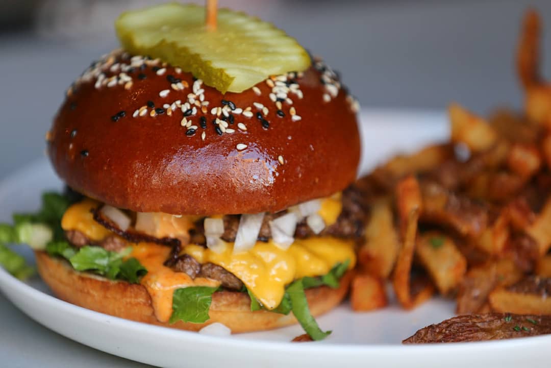 This is The Ivy Burger from  @ivycle Two beef patties with American cheese, special sauce, lettuce and onion on a toasted sesame seed bun. Served with house made fries.   #ClevelandBurgerWeek  #BurgerWeekCLE  @CLEburgerweek