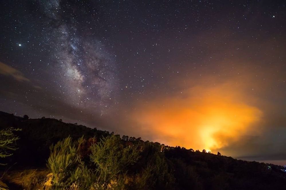 elbuencanario's tweet photo. Sobrecogedora foto de La Palma. El mejor cielo del mundo y el terrible incendio de Garafía. 
📸 Kike Navarro para Radio Luz. https://t.co/0dTklZMIsj