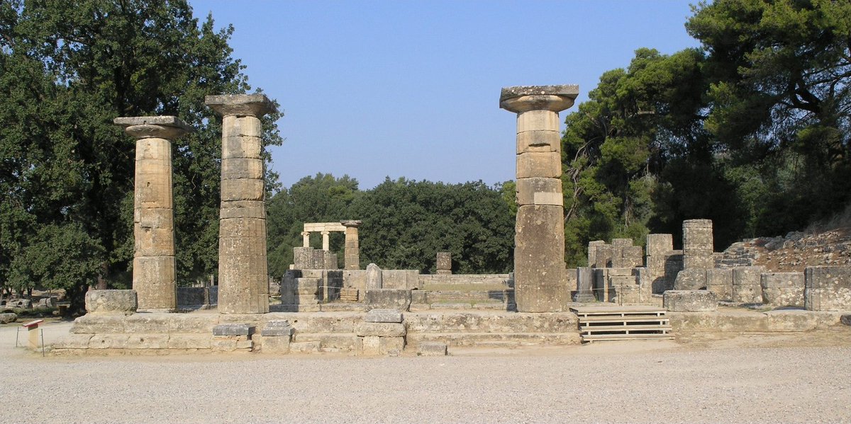 Le revers montre les ruines du temple d’Héra à Olympie et le discobole de Myron, sculpteur du Vème siècle. L’original en bronze est disparu mais nous le connaissons grâce à des reproductions postérieures en marbre. Elle représente un laceur de disque en pleine action.