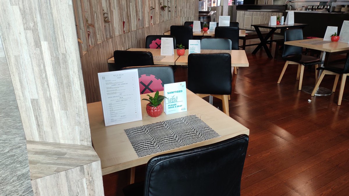 'Sanitized' placards are placed on dining tables with diagonal seats marked.