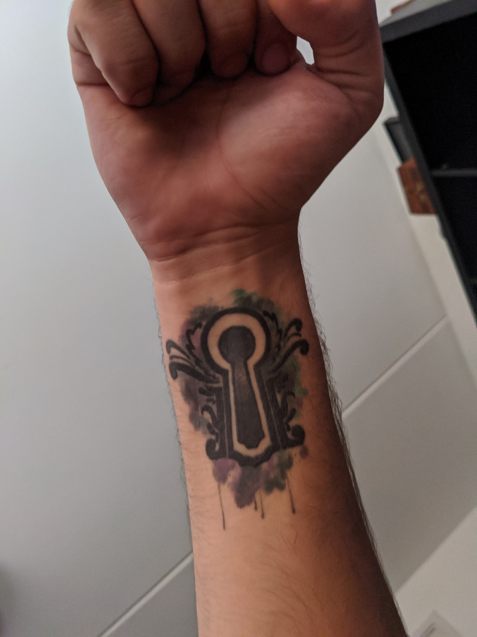 Keyhole tattoo on the right wrist.