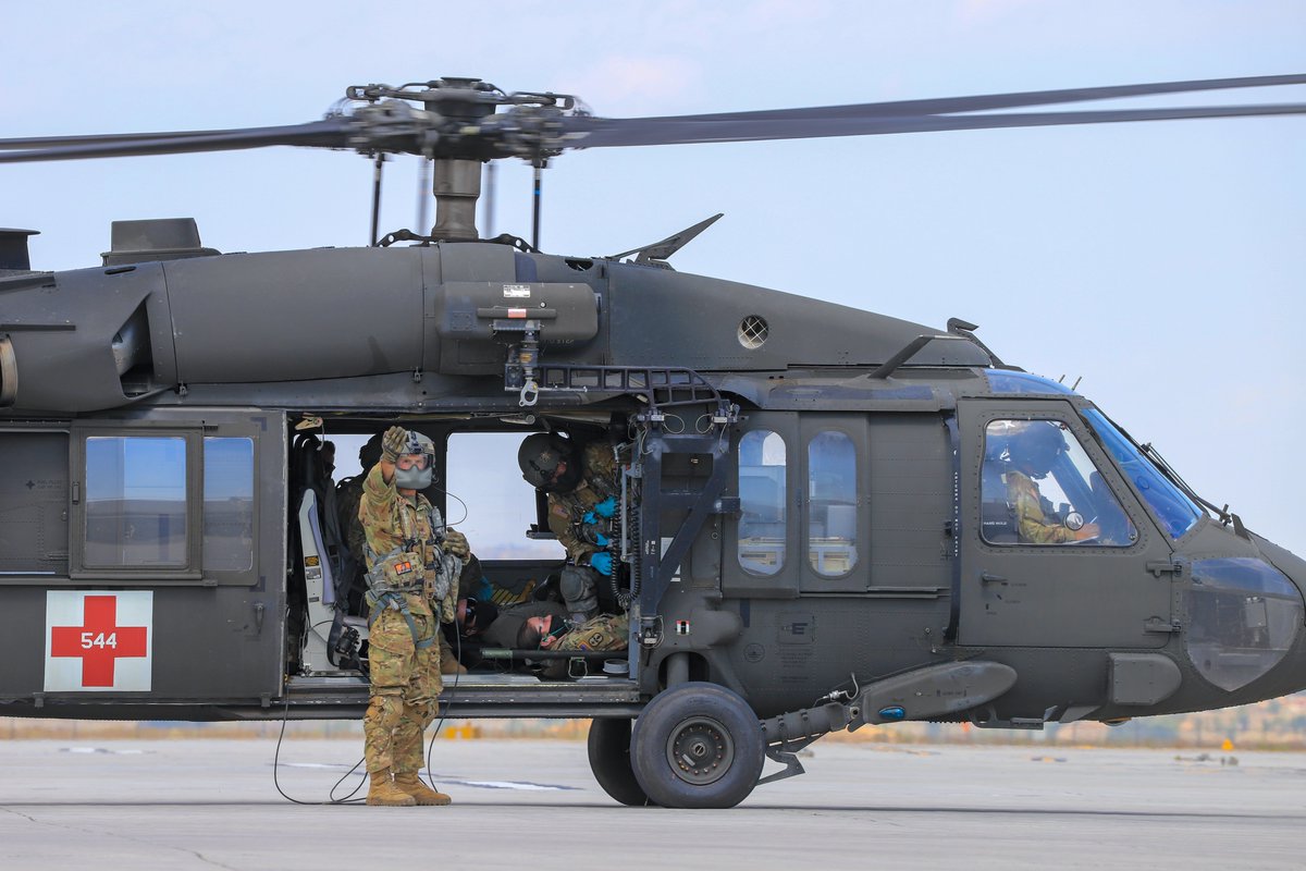 11thECAB's tweet photo. During Exercise #MountainMedic, Sgt. Christopher Buttner, a @USArmyReserve crew chief with 7-158 GSAB, signals to the litter team to recover a patient from the aircraft at the Role 2 facility in Fort Carson, Colorado. #Training #Readiness https://t.co/uiUepbijUI