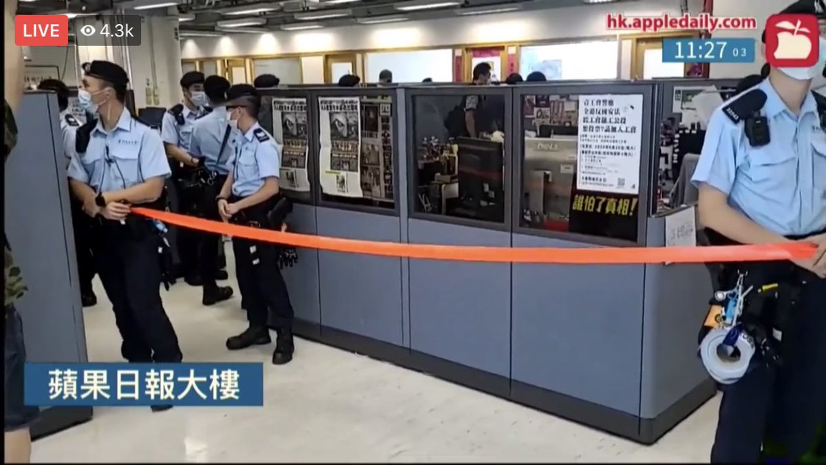 kanis_leung's tweet image. Police set up a cordon line inside the office building of Apple Daily when they conduct a search in the newsroom. Apple Daily reporters have to stand behind the cordon line at their own office. There is a lil poster printed with “who’s afraid of the truth!”
