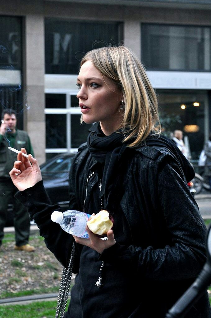 vladasdoll's tweet image. sasha pivovarova eating an apple while smoking a cigarette, leaving d&amp;amp;g show @ mfw