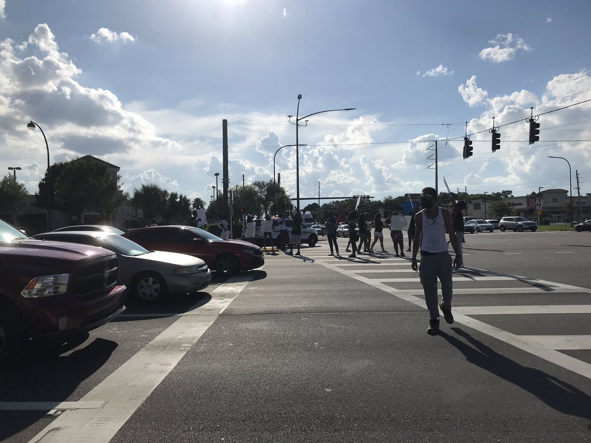 Group is now at the intersection of OBT and Sand Lake Road, stopping traffic at some points, in the intersection. Most traffic keeps going, many honk. They yell: “Black Lives Matter!” “Say his name: Salay Melvin!”“No Justice, No Peace!” “Hands up, Don’t shoot!”