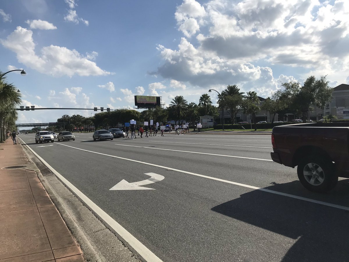 Group is now at the intersection of OBT and Sand Lake Road, stopping traffic at some points, in the intersection. Most traffic keeps going, many honk. They yell: “Black Lives Matter!” “Say his name: Salay Melvin!”“No Justice, No Peace!” “Hands up, Don’t shoot!”