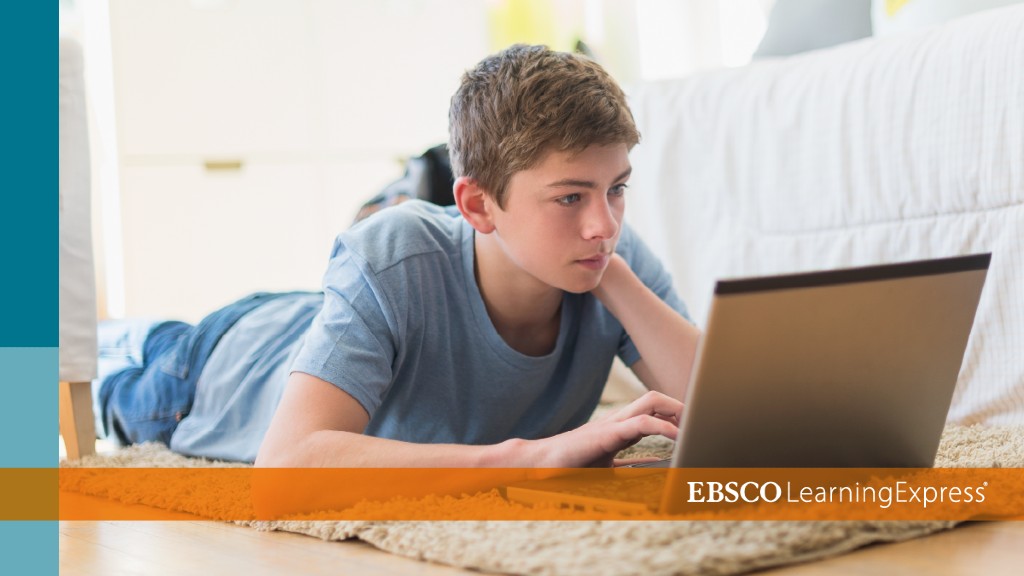 a teenage boy laying down on his bed, facing a laptop