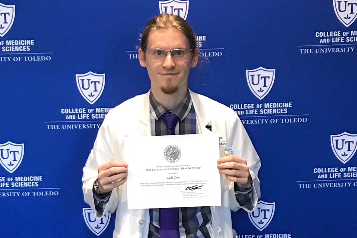 Photo of fourth-year medical student Luke Zona holding a certificate.