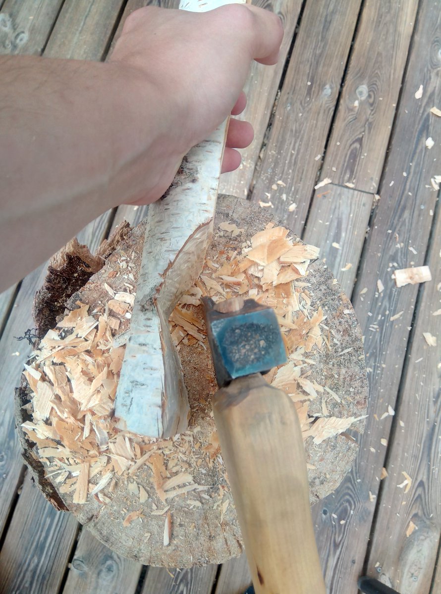 The tools I use - Mora 120, hook knife, selfmade axe, saw and sandpaper. I begin with making a crank. I do so by doing a saw cut where the bowl starts and then I use my axe to chop down towards it.