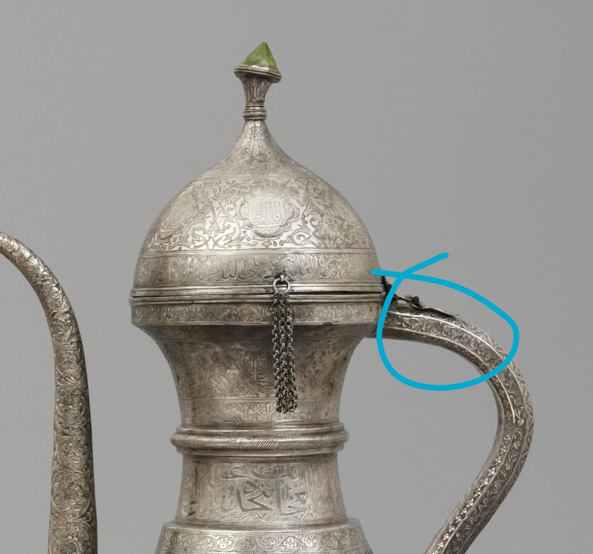 The ice would be added through the mouth of the ewer, while the liquid would be poured in through a small hole at the top of the handle, which is hollow. The external fittings here (spout, lid, & handle) are all silver; the ice container is copper alloy. [3]