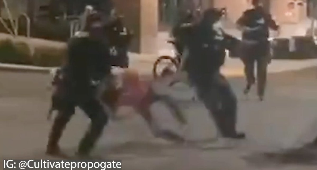 In the process, the original officer takes a step back and appears to possibly twist or hyperextend his knee. Neither the protester or anything else appears to make contact with his knee. Seeing the man writhing on the ground, the woman appears to move to help him and is tackled.